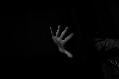 Cropped image of person hand against black background