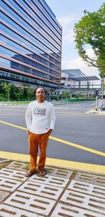 Portrait of smiling man standing against building in city