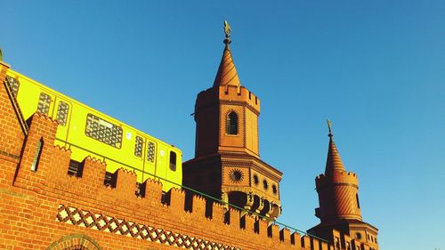 Low angle view of train on oberbaumbrucke against clear blue sky