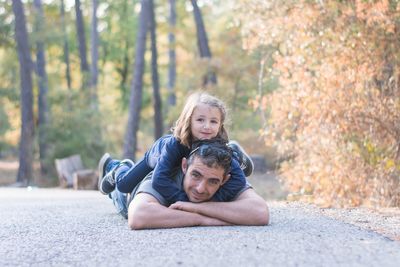 Portrait of happy mother with daughter against trees