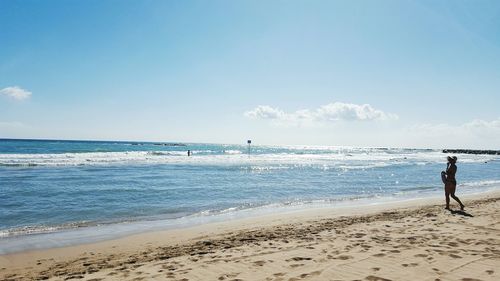 Woman walking on sandy beach