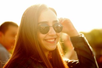 Portrait of a smiling young woman against sky