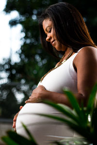 Side view of pregnant woman standing outdoors