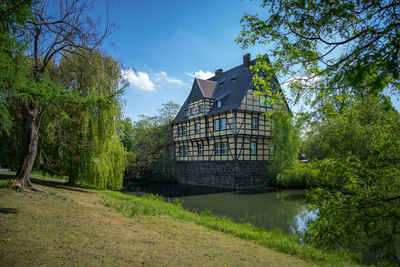 Built structure by river against sky