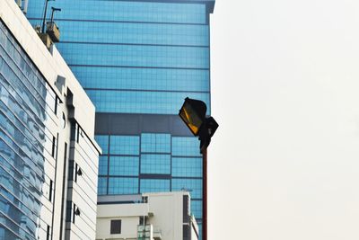 Low angle view of modern glass building against clear sky