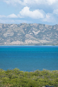Scenic view of sea and mountains against sky