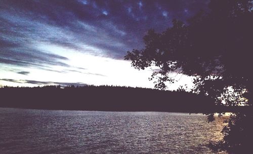 Scenic view of river against cloudy sky