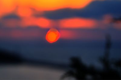 Defocused image of silhouette against sky at sunset