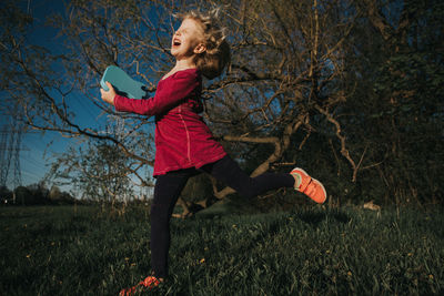 Girl playing with small guitar on field