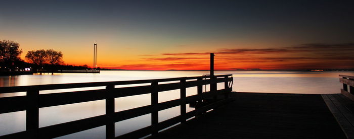 Pier on sea at sunset