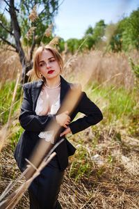 Portrait of young woman standing on field