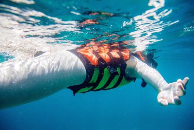 Low section of person swimming in sea