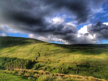 Scenic view of field against storm clouds