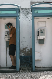 Midsection of woman standing by telephone booth