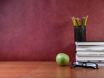 Multi colored pencils on table against wall