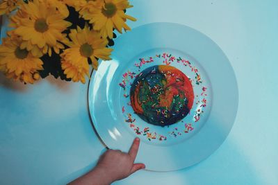 Cropped hand of girl pointing at sweet food in plate over table