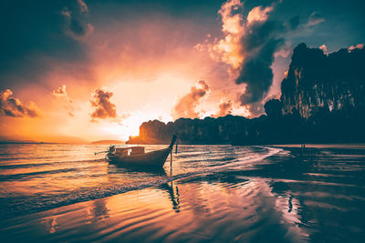 Silhouette boat in sea against sky during sunset