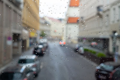 Cars seen through wet glass window in rainy season