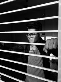 Young man looking through window