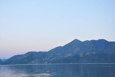 Scenic view of lake and mountains against clear sky