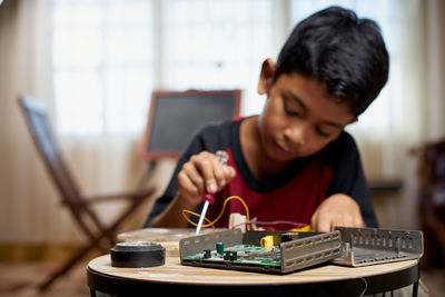 Side view of boy using laptop on table