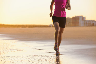 Woman running on beach at dusk