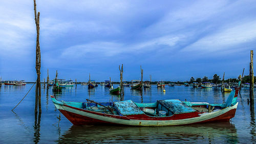 Boats moored in sea against sky