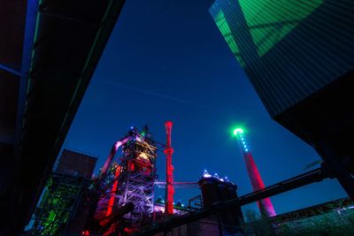 Low angle view of illuminated buildings against sky at night