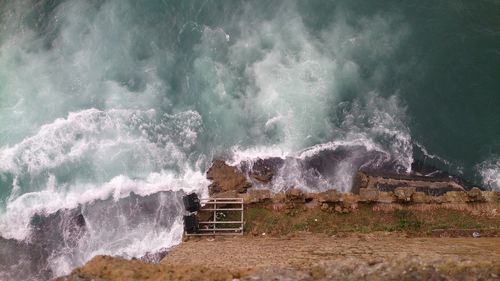 Waves splashing on rocks by sea