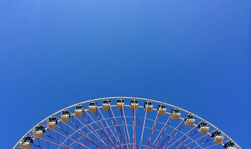 Low angle view of ferris wheel against blue sky