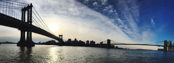 Manhattan bridge over east river against sky during sunset in city