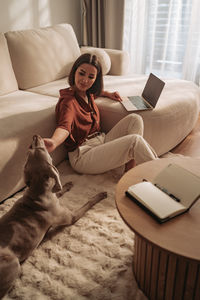High angle view of woman with dog on bed at home