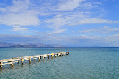 Ipsos beach pier in corfu a greek island in the ionian sea with a view of the albanian coast