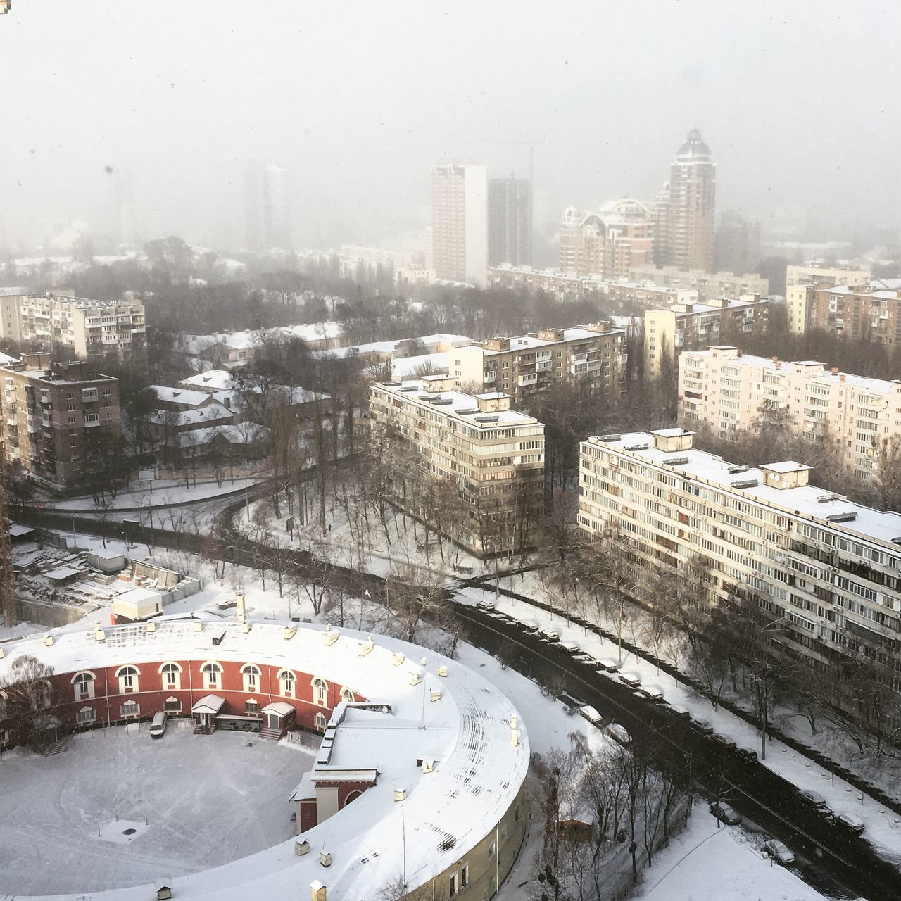 architecture, building exterior, built structure, city, water, cityscape, season, transportation, weather, high angle view, skyscraper, mode of transport, river, wet, glass - material, rain, modern, day, car, winter