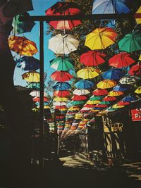 Low angle view of multi colored umbrellas hanging at market stall