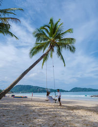 People at beach against sky