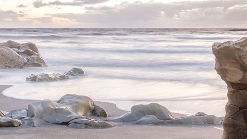 Rocks on beach against sky