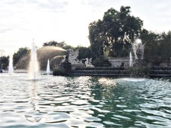 Fountain in lake against sky