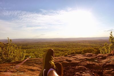 Low section of man on landscape against sky