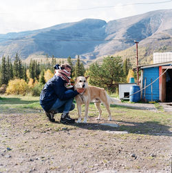 Woman sitting at the foot of the mountain with a dog