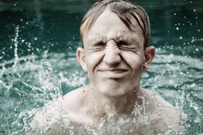 Close-up of teenage boy with eyes closed in swimming pool
