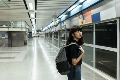 Full length of woman standing at subway station