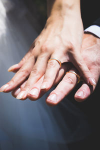 Cropped hands of couple wearing wedding rings