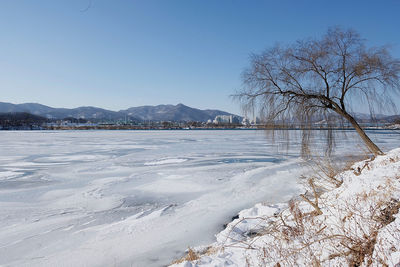 Scenic view of frozen lake against sky during winter