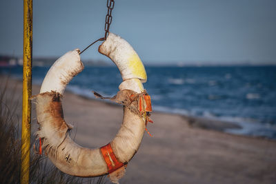 Close-up of rope on beach against sky