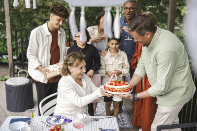 Family celebrating midsummer with cake at patio