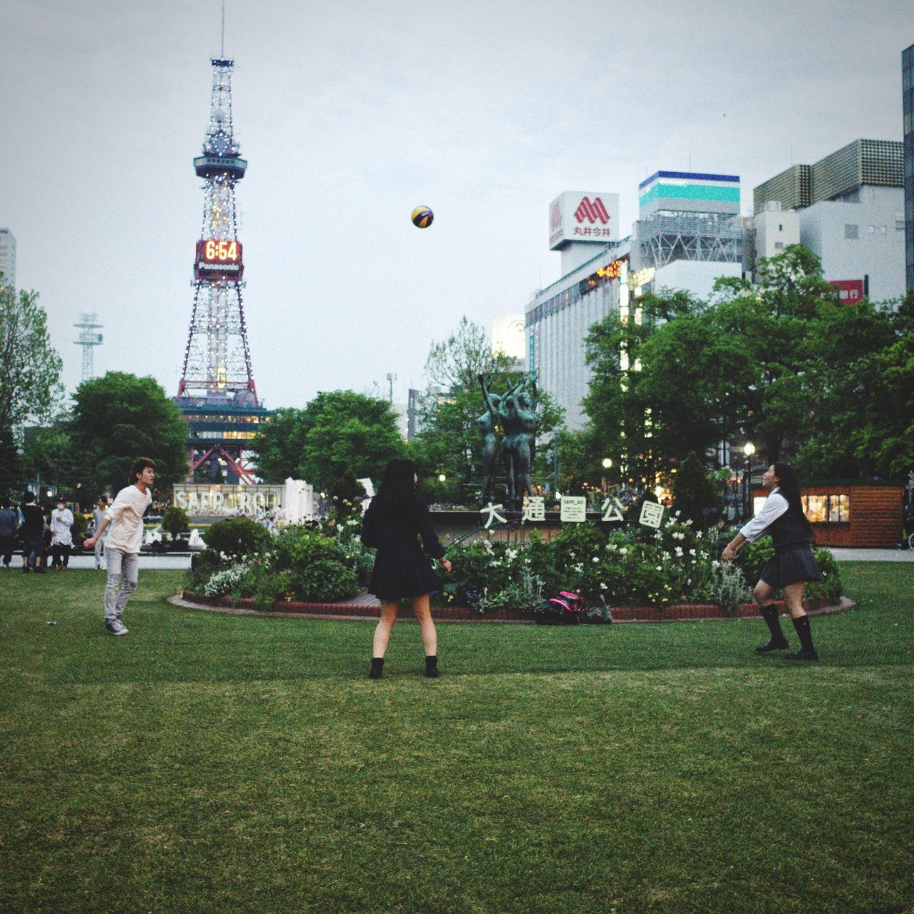 grass, real people, full length, leisure activity, architecture, built structure, men, casual clothing, building exterior, outdoors, city, travel destinations, women, lifestyles, sky, day, tree, large group of people, clear sky, friendship, nature, adult, people