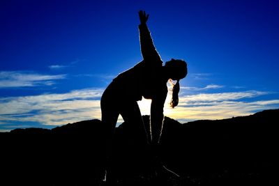 Silhouette man standing against blue sky during sunset