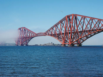 View of bridge over river against blue sky