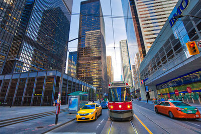 Vehicles on road amidst buildings in city